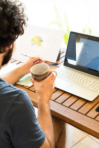 Rear view of man using laptop