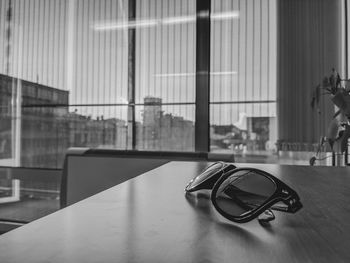 Close-up of sunglasses on table by window