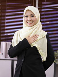 Portrait of smiling businesswoman wearing hijab in office