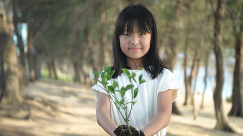 Portrait of woman standing against plants