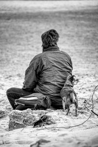 Rear view of man sitting on bench