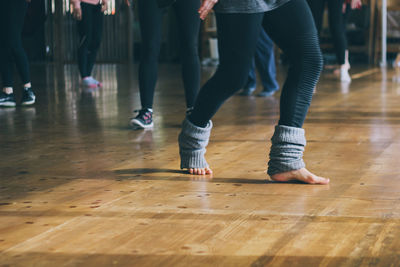 Low section of woman standing on hardwood floor