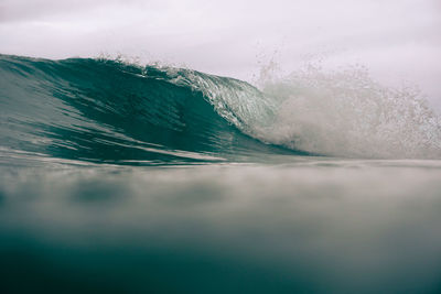 Water splashing in sea against sky