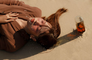 HIGH ANGLE VIEW OF WOMAN LYING DOWN AT HOME