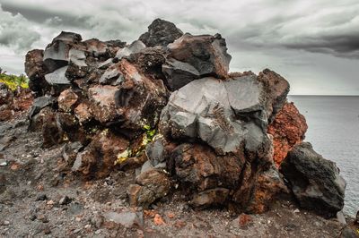 Close-up of rock formation in sea against sky