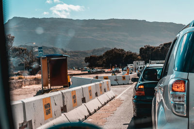 Vehicles on road against mountain range