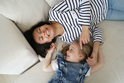 High angle view of cute baby girl sitting on sofa at home