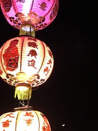 Low angle view of illuminated lantern against black background