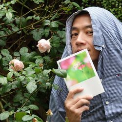 Close-up of woman holding flower with text