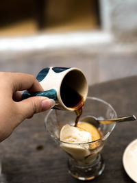 Cropped hand pouring coffee