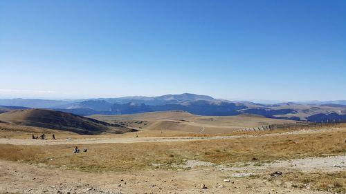 Scenic view of landscape and mountains against clear blue sky