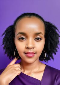 Close-up portrait of young woman against blue background