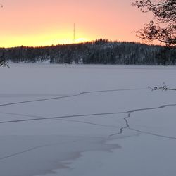 Scenic view of snow field against sky during sunset