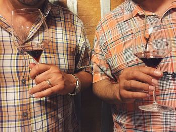 Midsection of friends holding wineglasses