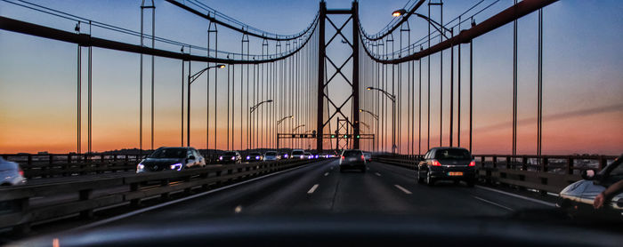 View of suspension bridge in city during sunset