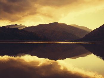 Scenic view of lake against mountains during sunset