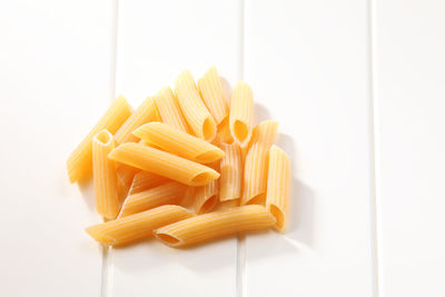 High angle view of raw pasta on white table