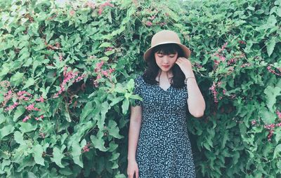 Full length of woman standing against plants