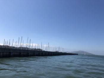 Sailboats in sea against clear blue sky