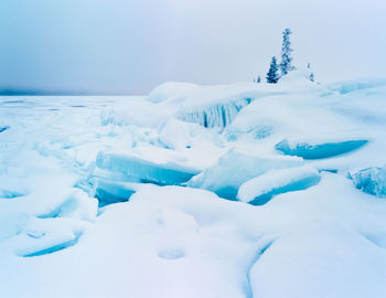 Snow covered landscape against sky