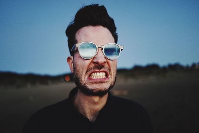 Close-up of angry man against clear sky