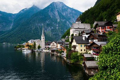 Town by river and mountains against sky