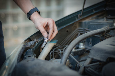 A young man holds a burnt out headlight bulb.