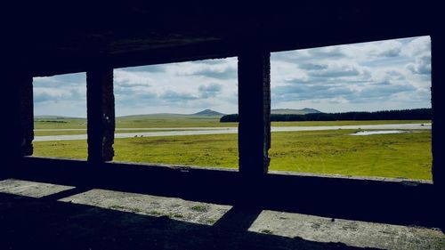 Scenic view of field against sky seen through window