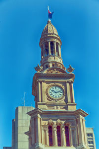 Low angle view of clock tower against blue sky
