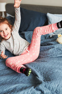 Portrait of playful girl on bed at home