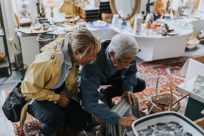 Heterosexual couple examining picture frames in antique shop