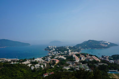 High angle view of townscape by sea against sky