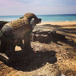 View of animal sculpture on beach against sky