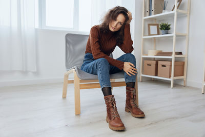 Portrait of young woman sitting on sofa at home