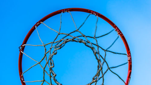 Low angle view of basketball hoop against blue sky