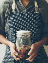 Midsection of woman holding food in jar