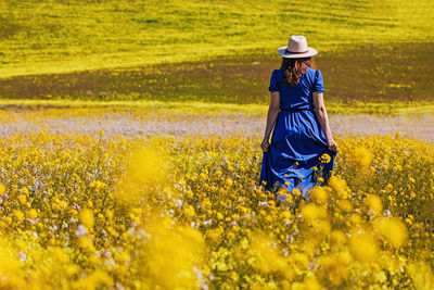 Rear view of woman walking on field