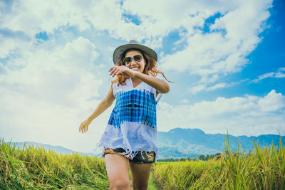 Smiling young woman walking on landscape