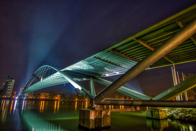 Low angle view of illuminated bridge against sky at night