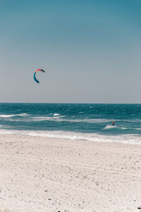 Distant view of man kiteboarding in sea