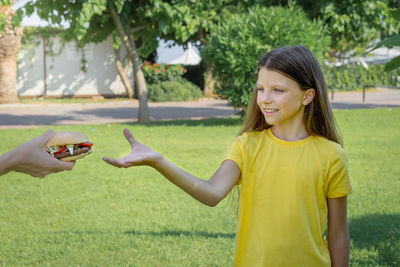 A teenage girl reaches for a burger with her hand. selective focus.