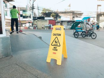 People on road sign in city