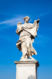 Low angle view of statue against blue sky