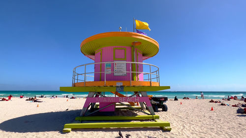 Lifeguard hut on beach against clear blue sky