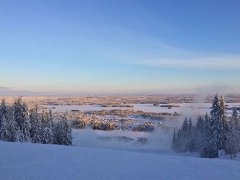 Snow covered landscape against blue sky