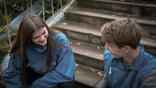 High angle view of friends sitting on staircase