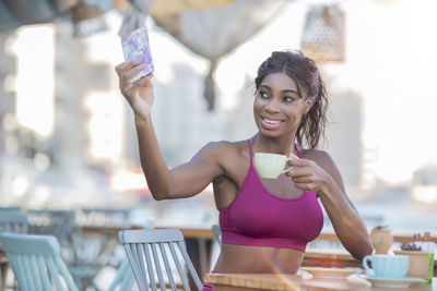 Portrait of a smiling young woman holding drink