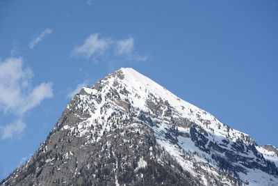 Low angle view of snowcapped mountain against sky