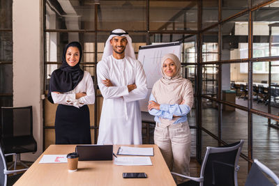 Portrait of female friends standing in office