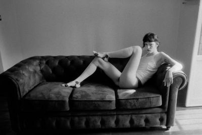 Young woman sitting on sofa at home